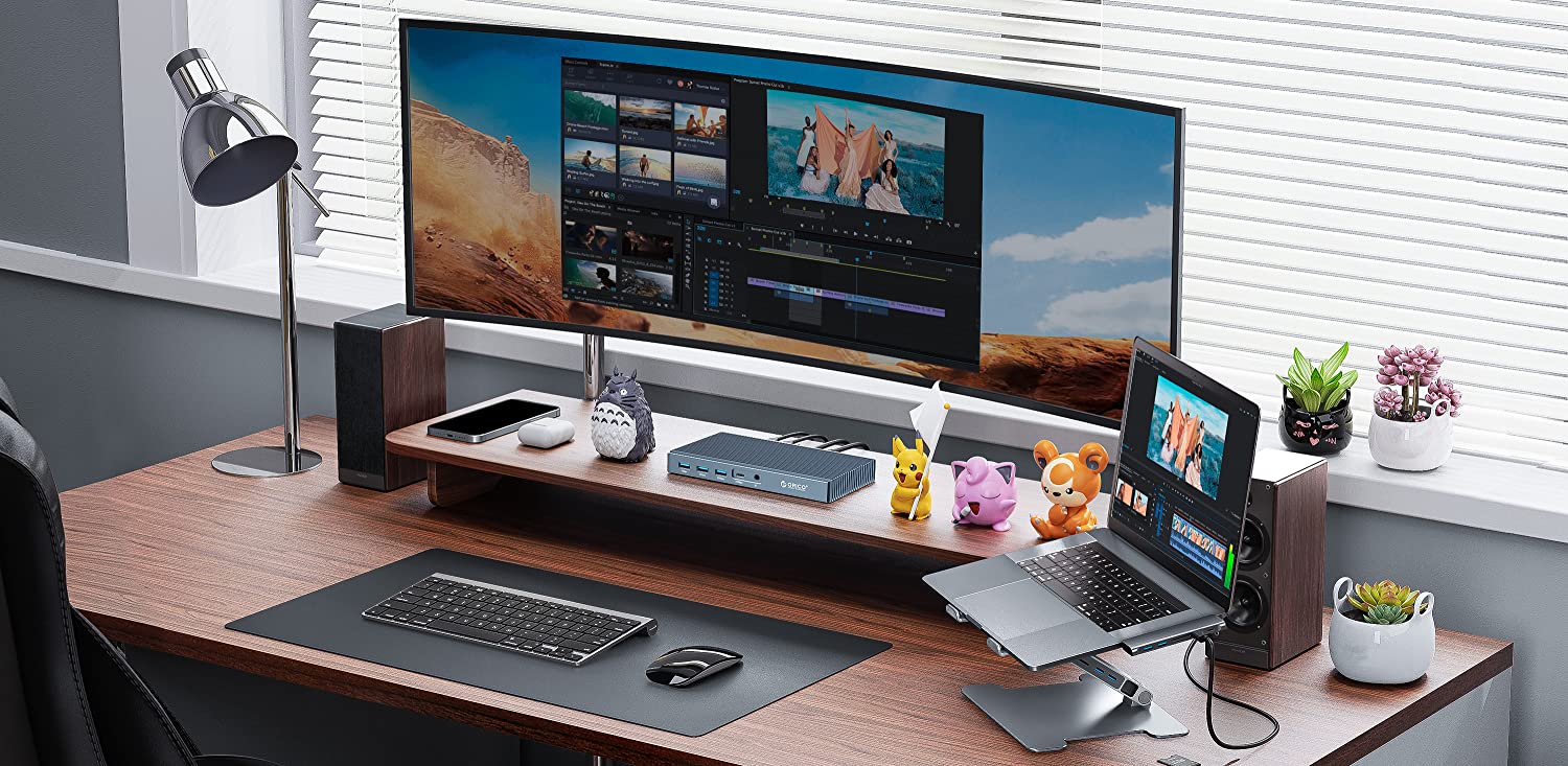 Biurko na którym stoi monitor i leżą narzędzia do pracy biurowej